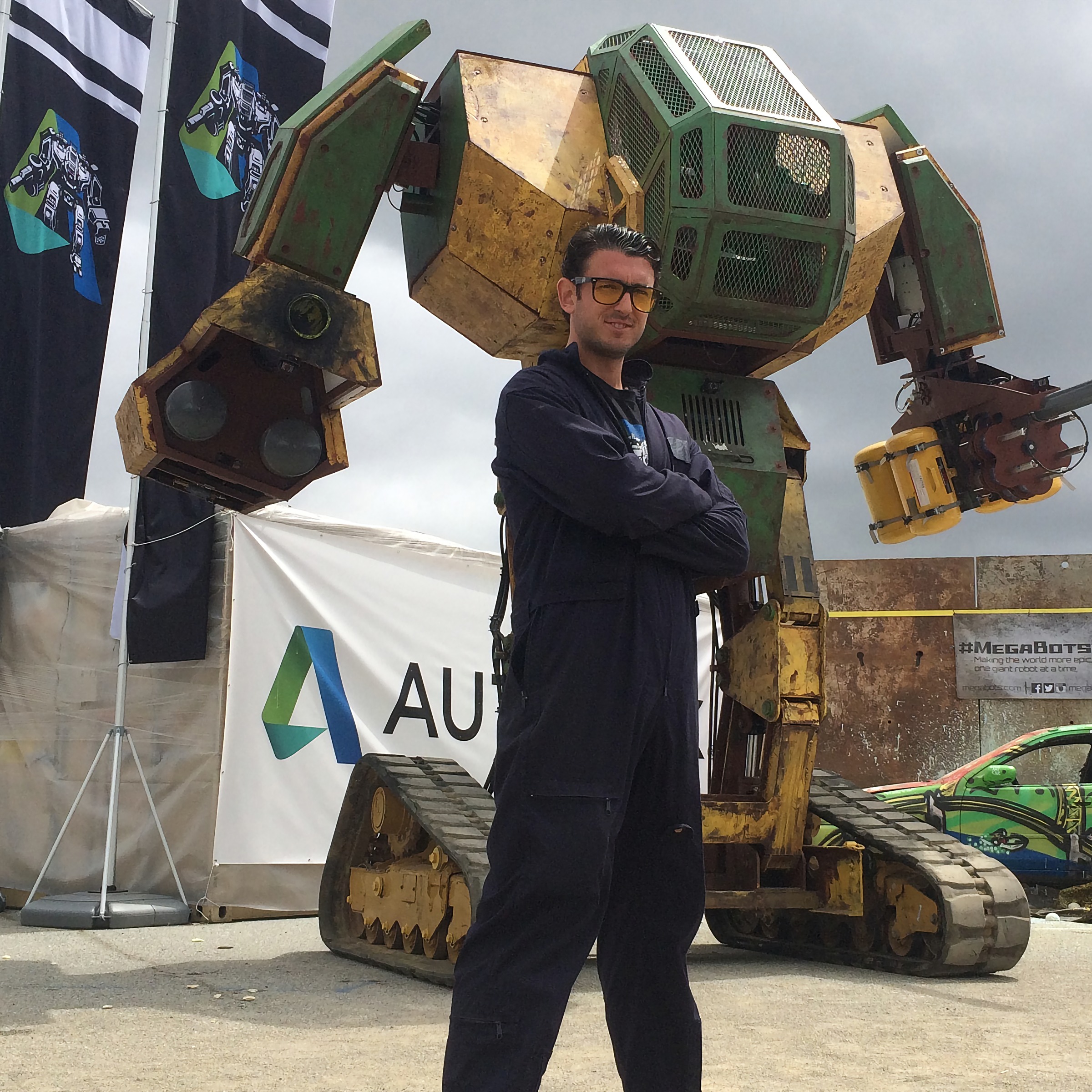 Brinkley Warren standing beside the MegaBot Mark II, the giant human-piloted fighting robot he co-created at MegaBots.
